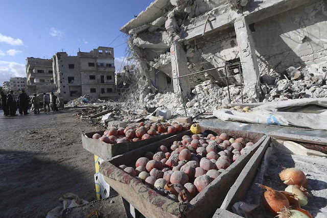 Procura de vítimass em mercadinho arruinado por bombardeio da força aérea da Rússia, em Ariha, província de Idlib.