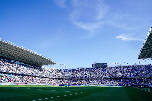 Los equipos en el centro de La Rosaleda, en el minuto de silencio por Javier Imbroda. MÁLAGA C. F. 2 REAL VALLADOLID C. F. 2 Sábado 09/04/2022, 18:15 horas. Campeonato de Liga de 2ª División, jornada 35. Málaga, estadio de La Rosaleda: 18.004 espectadores.