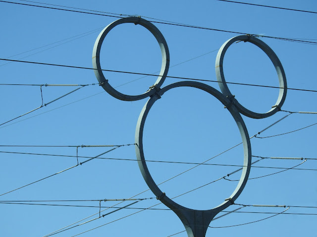 Hydro lines and a transmission tower shaped like a Mickey Mouse head.