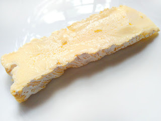A slice of Brie de Meaux cheese.