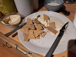 crackers and houmous on a beige plate