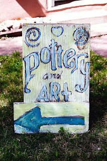 a hand-painted sign advertising pottery and art