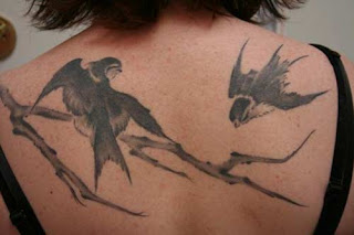 Sparrow tattoo on back body girl
