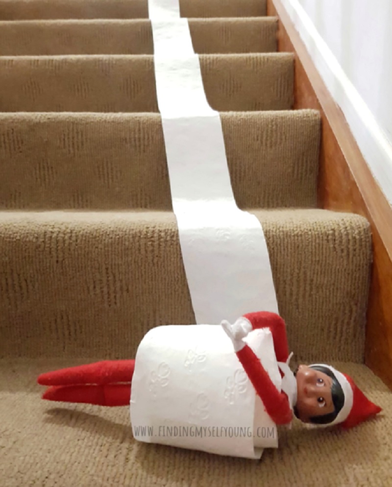 elf rolling down the stairs in toilet paper