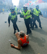 Police officers with their guns drawn hear the second explosion (boston explotion)