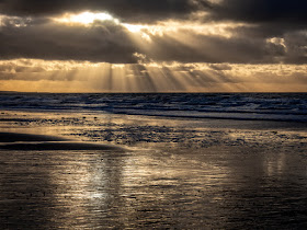 Photo of sun breaking through dark clouds over the Solway Firth in Cumbria, UK