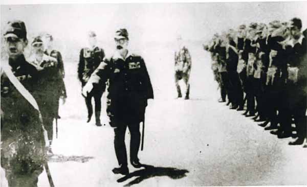 General Hideki Tōjō, who is also the Prime Minister of Japan inspecting an airfield in Kuching, while soldiers giving a salute