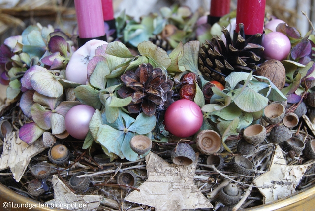 Zwischen den Hortensienblüten Zapfen, Kugeln, und Hagebutten befestigen