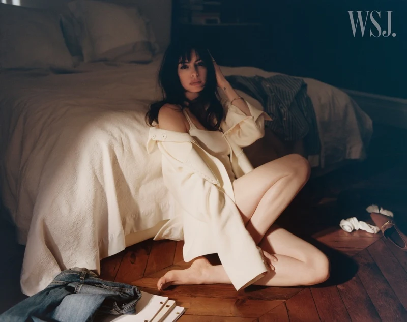 Actress Anne Hathaway wears Fendi dress and jacket while posing in a bedroom. Photo: Dan Martensen for WSJ. Magazine