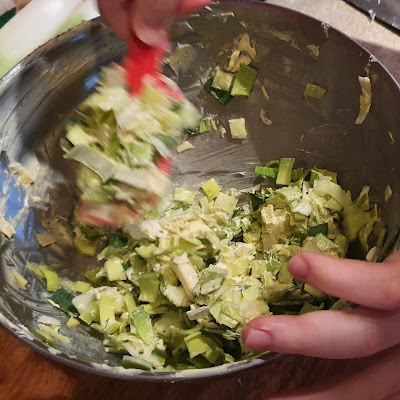 Leek and garlic bread filling being mixed in a big silver bowl