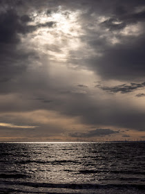 Photo of sun breaking through heavy clouds over the Solway Firth