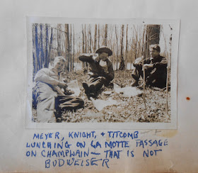 Three students eating lunch and drinking beer near Lake Champlain. Caption includes "That is Not Budweiser""