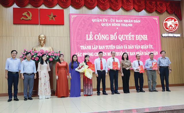 Đồng chí Vũ Ngọc Tuất, Bí thư Quận ủy và đồng chí Triệu Lệ Khánh, Phó Bí thư Thường trực Quận ủy  trao quyết định, tặng hoa chúc mừng Ban Tuyên giáo và Dân vận Quận ủy. (Ảnh: Anh Hoàng)