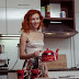 Fiery red haired girl undressing in the kitchen