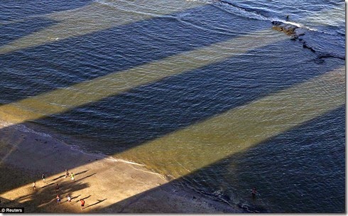 Men play soccer between the shadows of buildings on Boa Viagem Beach in Recife, Brazil, June 14 - Copy