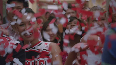 The glee club being showered in red and white confetti