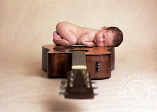 Foto bayi lucu tidur di atas gitar