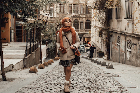 Stylish woman walking along narrow street