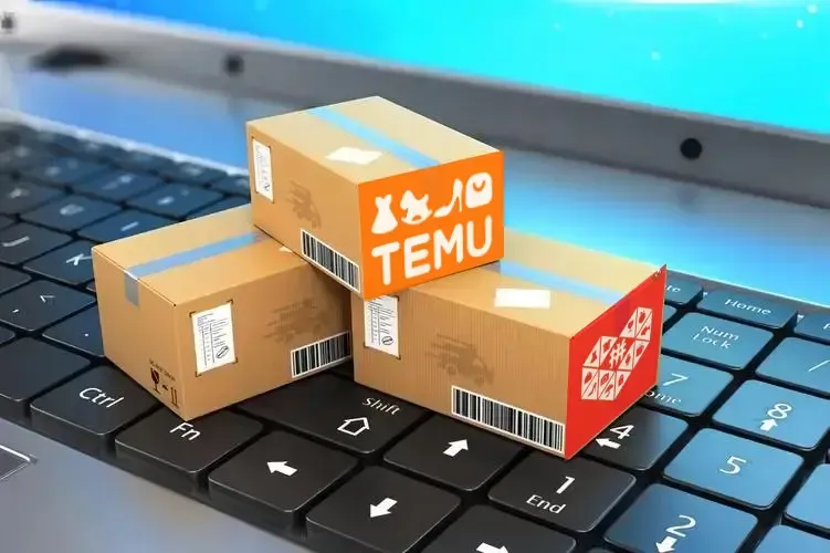 A close-up photo of three shipping boxes stacked on top of a laptop keyboard. The top box has the Temu logo and the bottom box has the Pinduoduo logo.  The laptop keyboard shows some keys including Enter, Shift, Control, Fn and End.