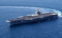 Aircraft carrier USS John C. Stennis making a sharp clockwise U-turn on the deep blue ocean. Picture by Tina Lamb, USN