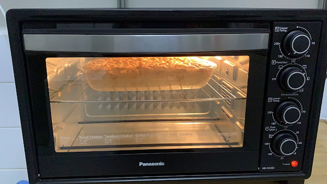 apple quick bread in glass pan baking in oven