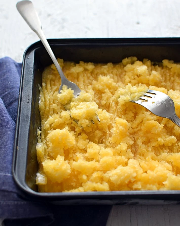 Granita o granizado de frutas en un molde de metal con tenedores para hacer el raspado