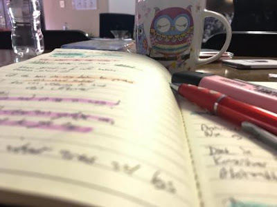 Notes in notebook, with coffee in background and Stabilo Boss highlighters