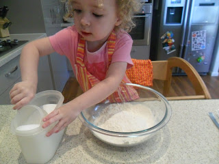 Measuring sugar into a bowl for muffin recipe