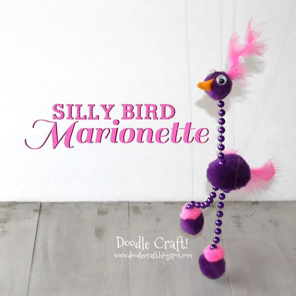 Pom pom Marionette bird made with mardis gras beads, pom poms and feathers.