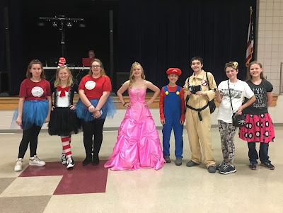 Group of middle school students in costumes. Cat in the hat, Thing 1 and Thing 2, Barbie, Mario, and Ghostbuster