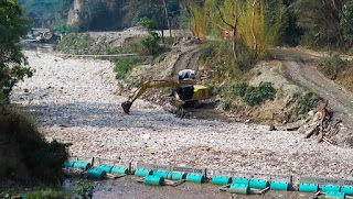 Une pelleteuse qui nettoie une rivière