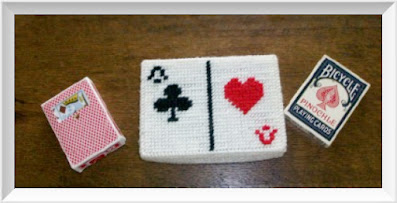 Two decks of playing cards and a card deck holder decorated with card symbols
