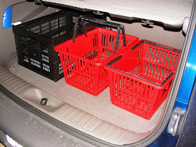 black collapsible crate (left) next to red browsing baskets sold by Demco library supply in back of car