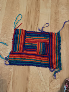 Using the same colors and stripe sequence as the first side, this shows the center square surrounded by the first four rectangles with the "extra" rectangle to the right side.