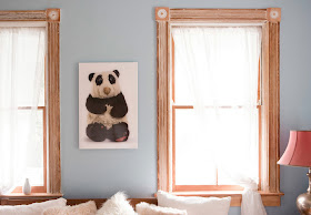 photo of old stuffed panda bear, hanging on the wall