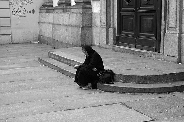 Una señora pide en la calle.