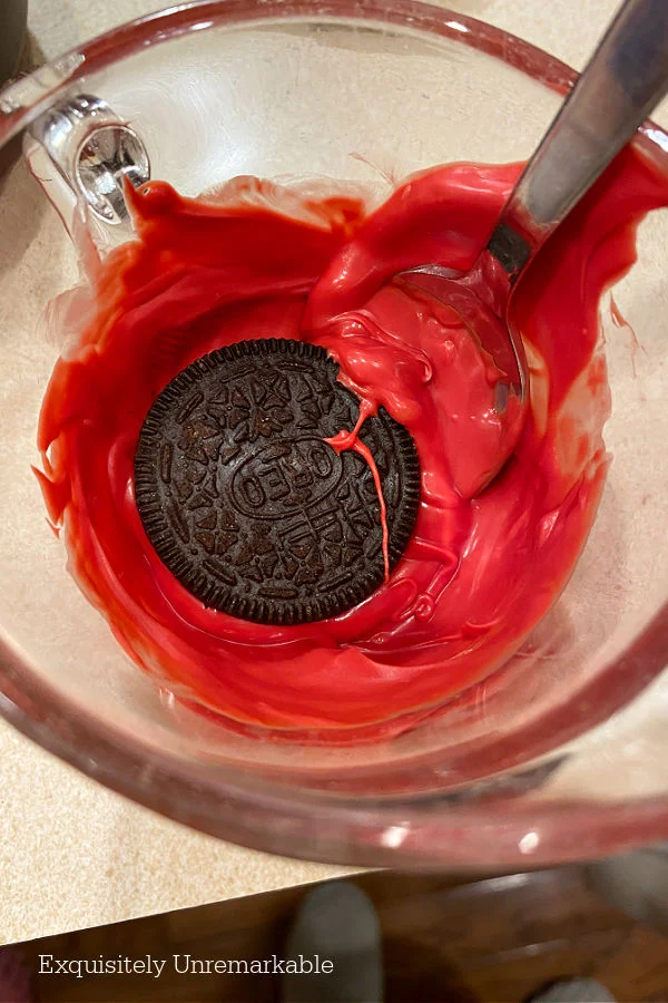 Oreo Cookie floating in red melted chocolate