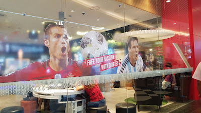 Singtel outlet with pictures of footballers and the slogan Free your Passion with Singtel. Taken at Jurong Point on 13 May. 