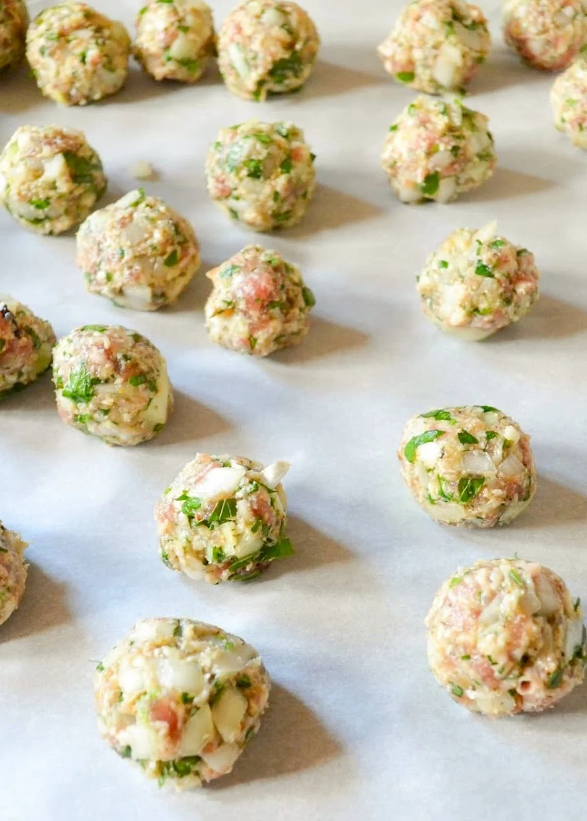 Italian Wedding Soup Meatballs on a parchment lined baking sheet.