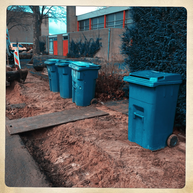 Afvalcontainers aan een straat met opengebroken stoep, Zonnemaat, Zevenaar, januari 2018. Hipstamatic: Dale + Ina's 1969. Foto: Robert van der Kroft