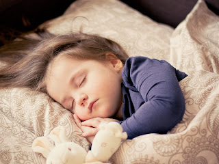 cute girl sleeping on bed with silky hair baby