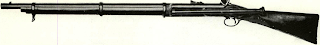 Left side of full stock Whitworth shows slightly different scope but position is same as on Battle Abbey Confederate specimen. Long eye-relief tube was located so because rifle was shot from “back position,” with muzzle balanced between shooter’s crossed feet and butt near cheek, lying on one’s back. Rifle shown, in N.R.A. (British) museum, has Enfield-type rear sight.