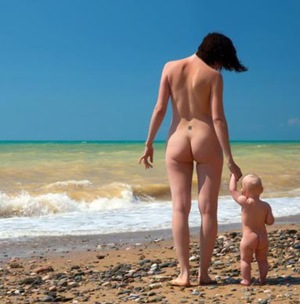 Madre con bambino nudismo in spiaggia selvaggia