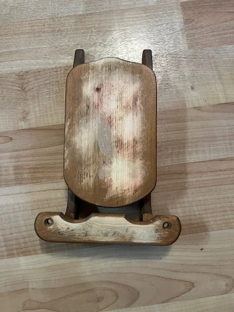 Photo of a small wooden sled with painted design sanded off before painting.