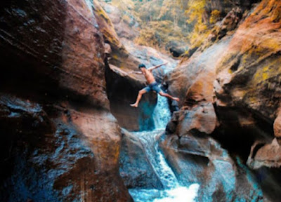 Air Terjun di antara tebing dan bebatuan di Desa Musi