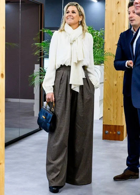 Queen Maxima wore a handmade melange wool coat by Massimo Dutti, and white blouse and wide leg pants by Natan. Susan Gail bag