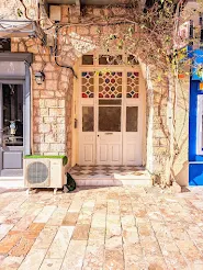 White door with stained glass and ivy in Nafplio Greece