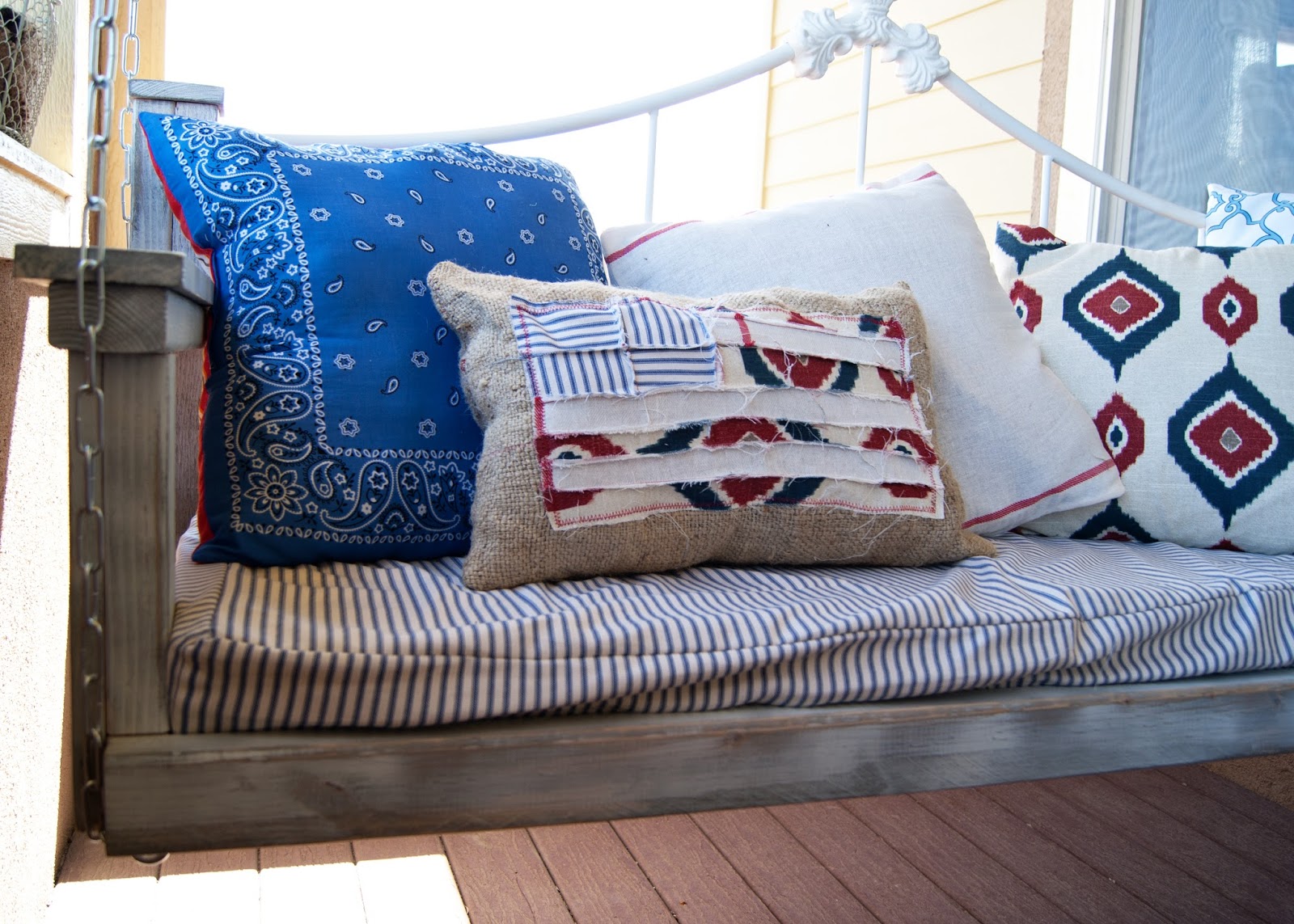 Scrappy Flag Pillow on porch swing