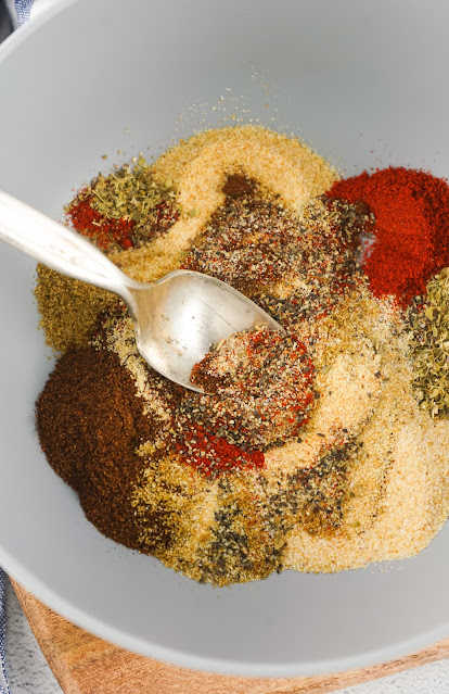 spices being mixed in a white bowl.