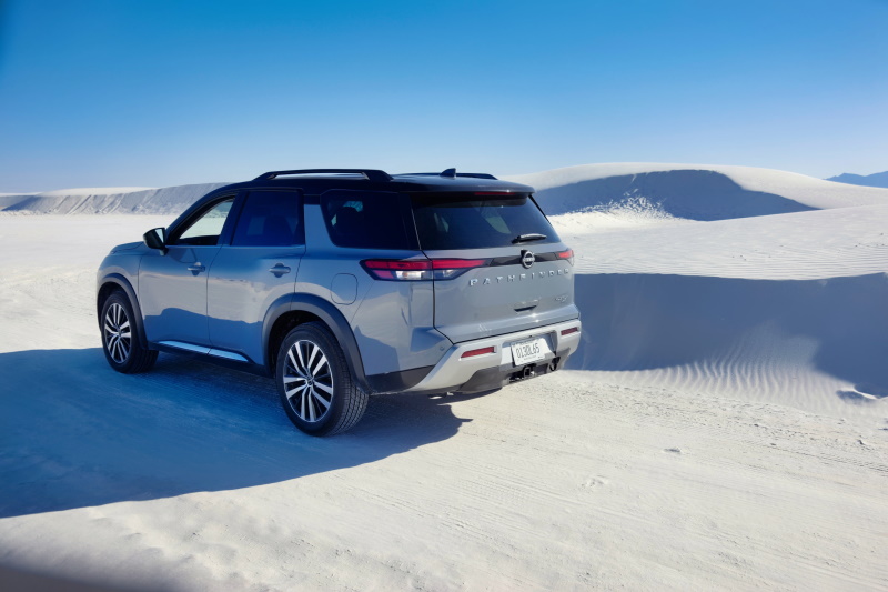 Nissan Pathfinder SUV in front of sand dune, White Sands National Park